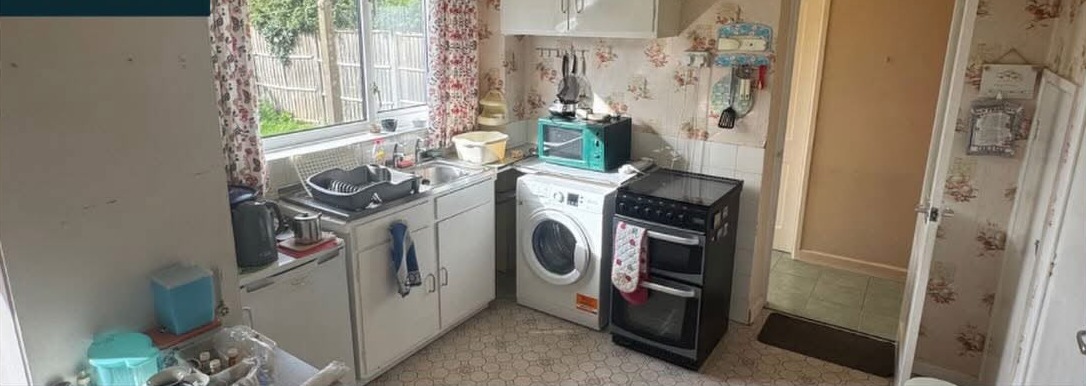 Kitchen before HFC clearance — appliances and clutter
