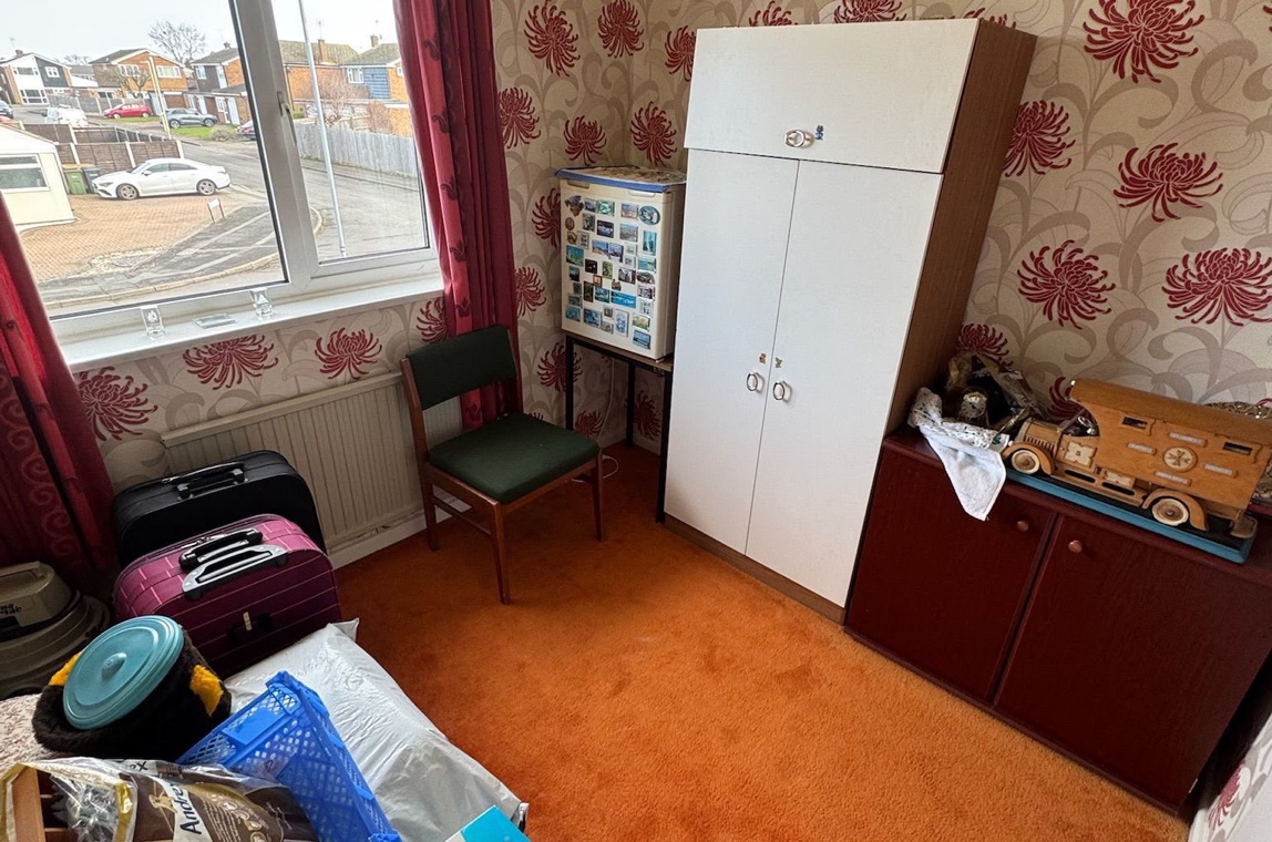 Bedroom in the Midlands before HFC clearance — full of clutter and belongings